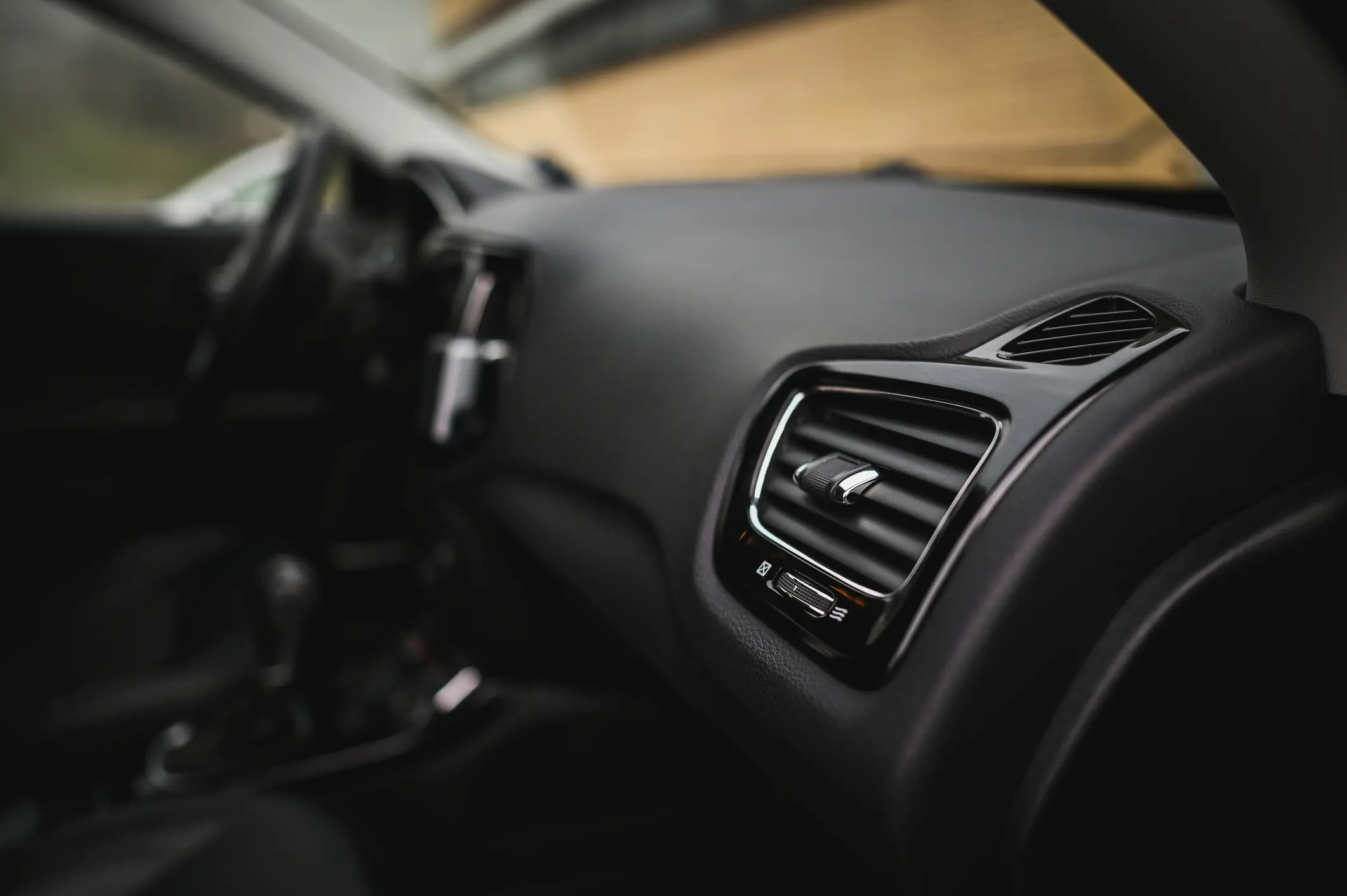 Car interior with dashboard air vent.