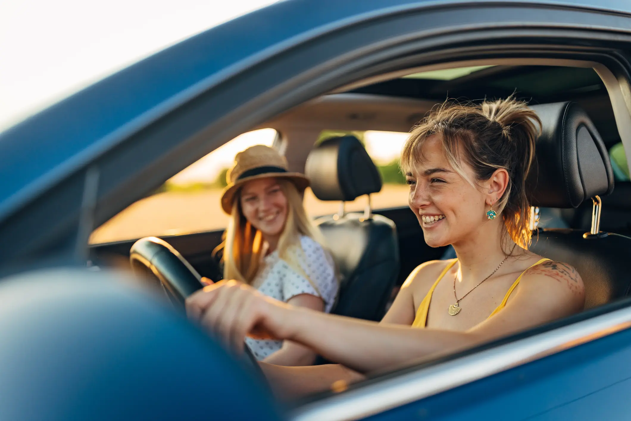 Two women smiling in a car.