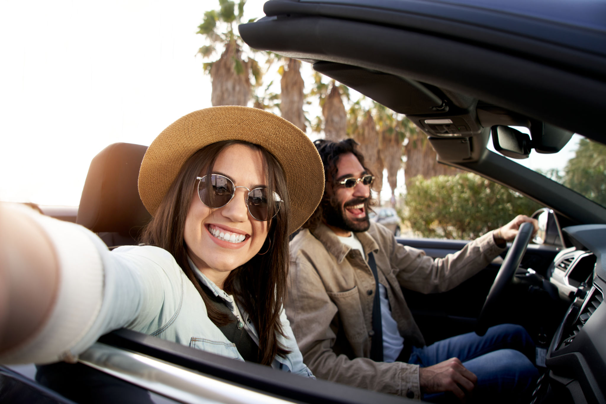 Couple taking selfie in convertible car